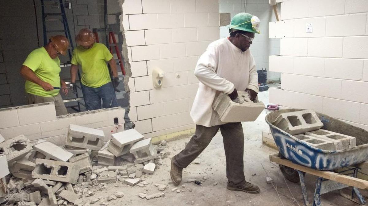 From right, Johnny Dunn, Chris Williams and Keith Skinner, workers for Tri Star Masonry, tear down a cinder block wall Friday where a new door will be built for a new teachers lounge at Porter Elementary School.