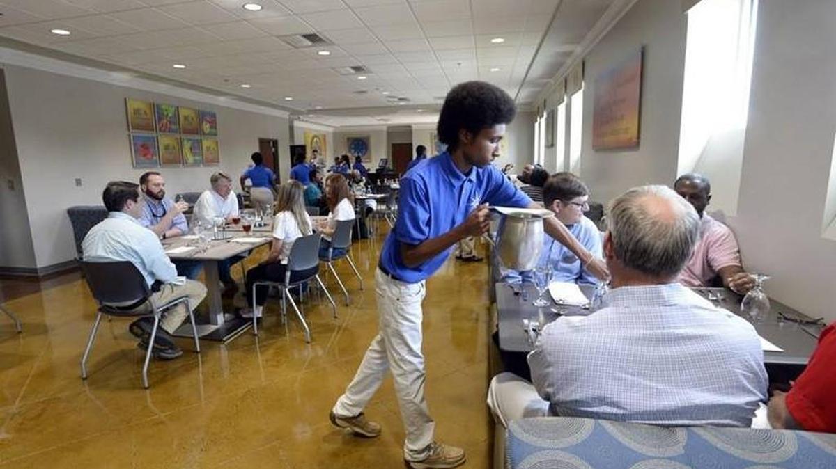 Student Jason Smith pours drinks for customers at Compass Rose Cafe at Hutchings College and Career Academy in January.
