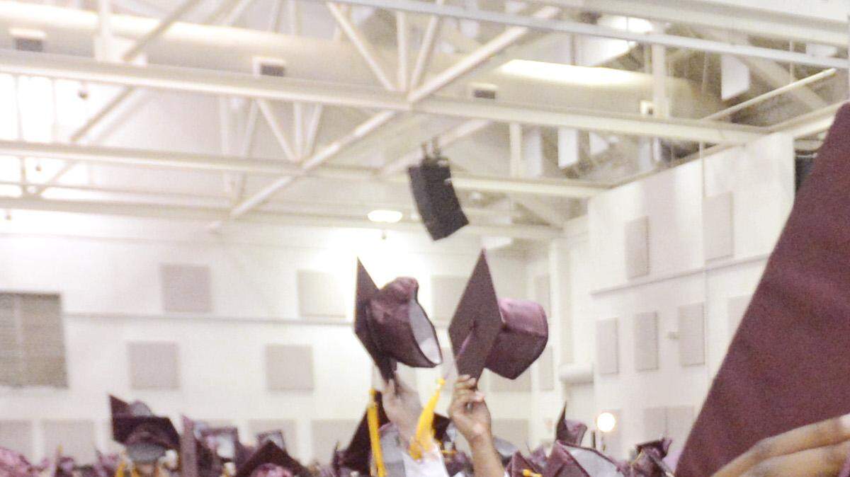 Perry senior Yohannes Hollis Jr. tips his cap with fellow  graduates during the school's 2014 commencement at the Georgia National Fairgrounds and Agricenter.