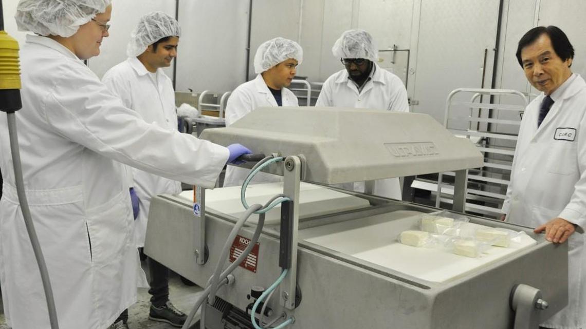 Dr. Young Park, at far right, coordinator and professor of Fort Valley State University’s food science program, assists students packaging goat cheese, using a double chamber vacuum packaging machine in the Georgia Small Ruminant Research and Extension Center on campus.