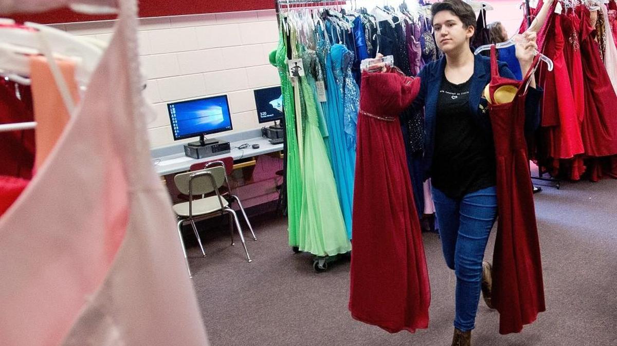 Warner Robins High School freshman Bela Venditti sorts through dresses while helping prepare for the Demon Dress Drive in February. The school is hosting another drive Aug. 26.