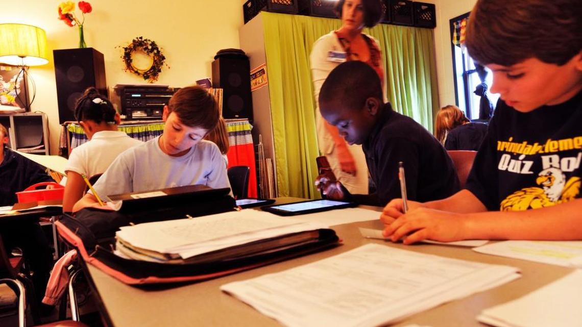 Springdale Elementary teacher April Hammett, standing, works with fifth-graders on social studies projects. Springdale made the Georgia Department of Education’s five-year “Beating the Odds” list.