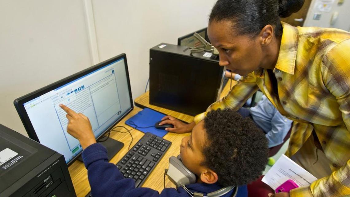 Vineville Academy 4th grade teacher April Harvey helps fourth-grader Ulric Bellaire with a question on a practice Georgia Milestone test in the school's computer lab. Milestones results are a key component of the College and Career Ready Performance Index, which will help determine which schools are eligible for the Opportunity School District.
