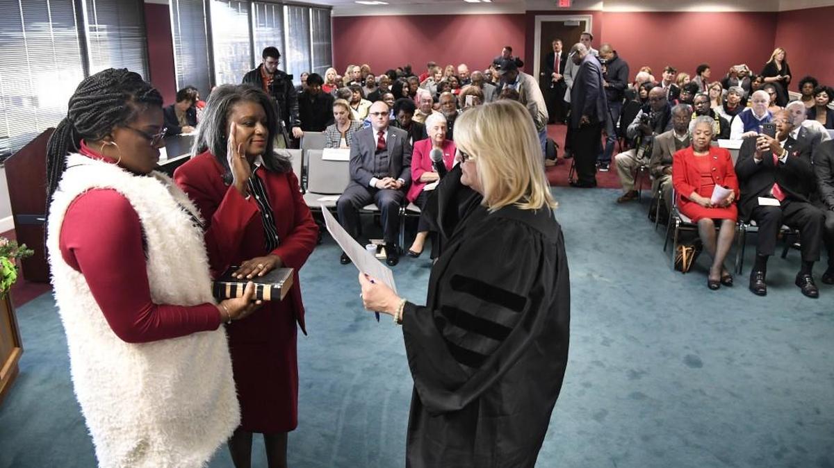 Sundra Woodford, center, is sworn in as a new member of the Bibb County Board of Education Thursday. Woodford’s daughter, Alexandra Woodford, held the family’s Bible while Judge Sarah Harris administered the oath.