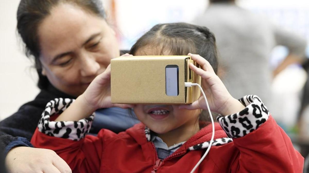 Mariana Arenal, 5, smiles as she looks at Aztec ruins with virtual reality goggles at the Cirrus Academy Charter School student recruitment fair Feb. 7. Mariana’s mother, Irena Arenal, is looking at her school options for her daughter.