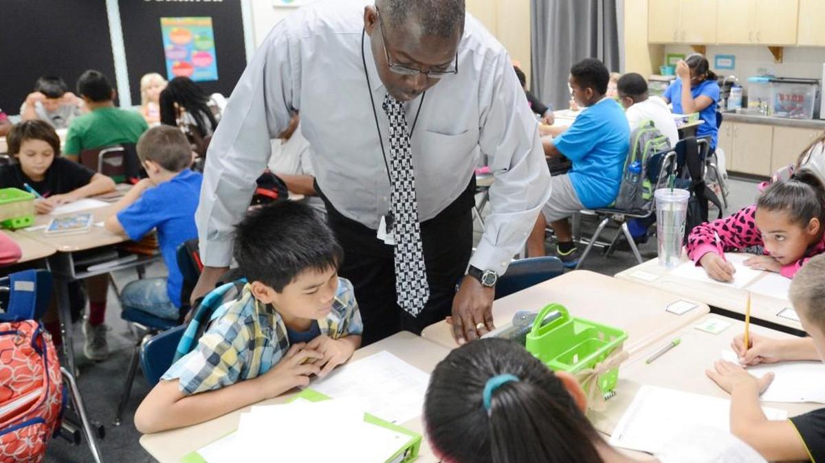 Substitute teacher Vince Lawhorn helps fifth-grade students with multiplication math problems at Perdue Elementary School in August 2015.