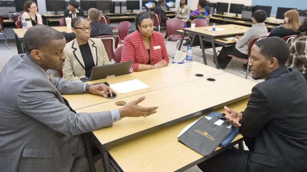 Taurus Wallace, right, is interviewed by members of the Howard Middle School staff, including sixth-grade teacher Eric Fuller, left, during the 2017 Bibb County teacher recruitment fair at Howard High School.