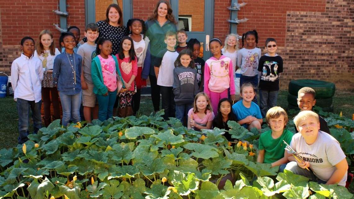 Northside Elementary School music teacher Marla Garnto, center, is pictured with her students in the school’s garden. She is one of eight national winners for a National Excellence in Teaching about Agriculture Award.