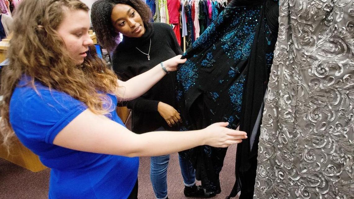 Warner Robins High School junior Nayahna Gordon, right, and senior Rebecca Walde look at a dress while helping prepare for the The 2017 Demon Dress Drive. The 2018 event is scheduled for Jan. 27.