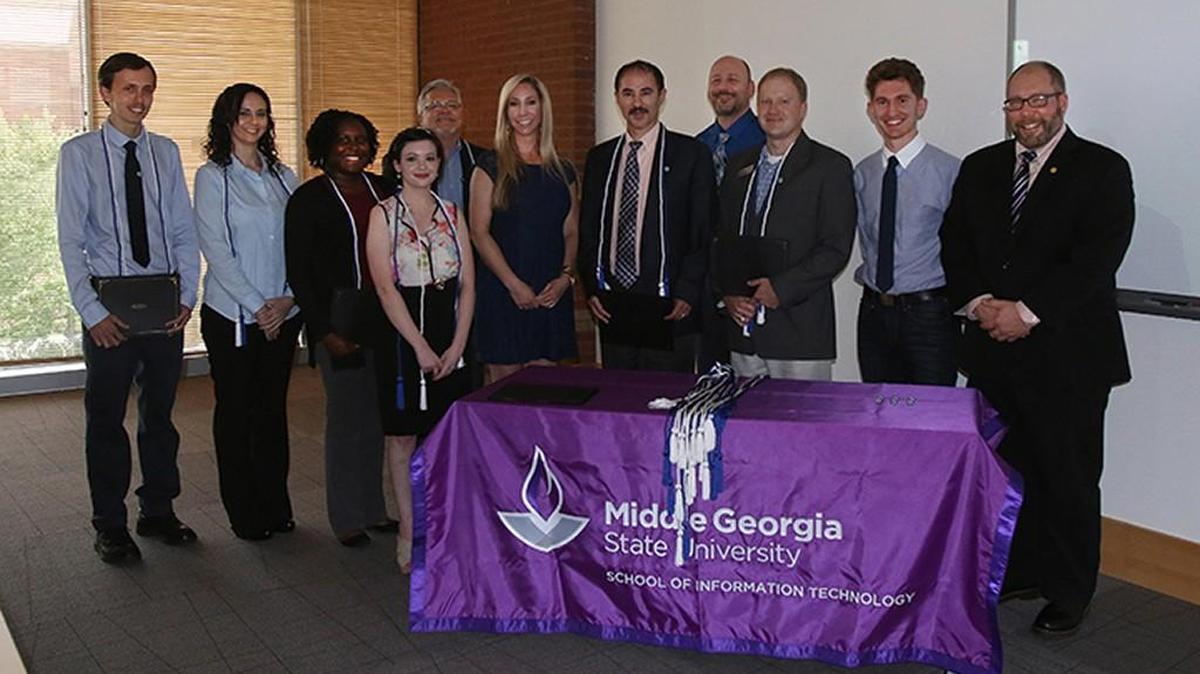 Middle Georgia State University inducted its first class into the Alpha Iota Mu honor society in May. Pictured, from left, are Mark Ashurst, Heather Harper, Vaquasha Rhodes, Alexandra Papadopoulos, Neil Rigole, Alpha Iota Mu President Kelly Jones, Middle Georgia State University Dean of the School of Information Technology Alex Koohang, Alpha Iota Mu Vice President Doug Smalley, IT school chairman Kevin Floyd, Alpha Iota Mu Treasurer Michael Koohang, and faculty adviser Scott Spangler.
