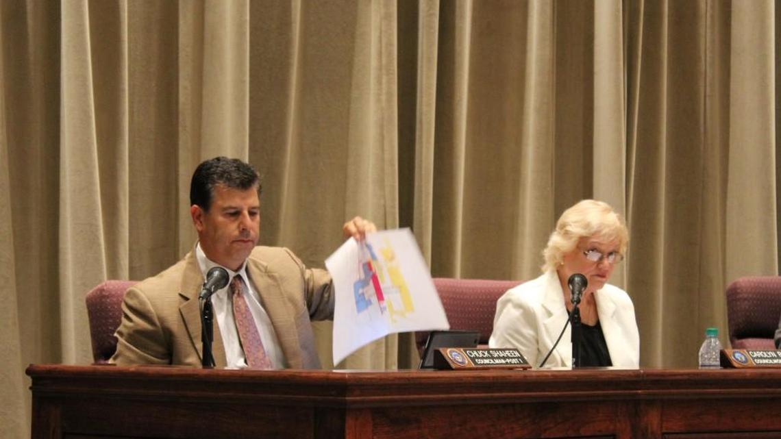 As Warner Robins Councilwoman Carolyn Robbins listens, Councilman Chuck Shaheen holds up a map that illustrates a legal dispute with the city of Byron that the council voted to settle Monday.