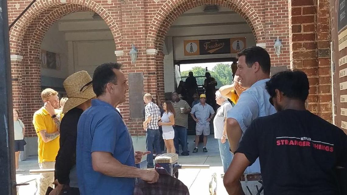 Hank Azaria talks with a staff member on the set of “Brockmire” at Luther Williams Field.