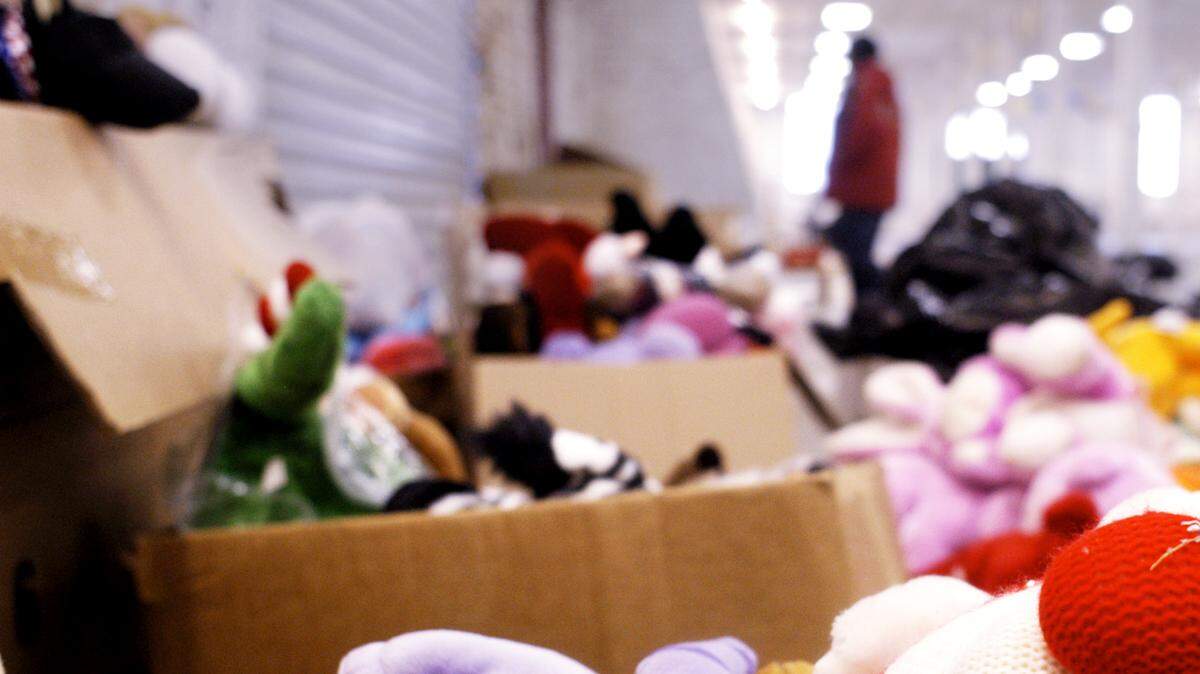 A Kids Yule Love volunteer walks past a heap of donated stuffed animals Christmas Eve morning in 2003.