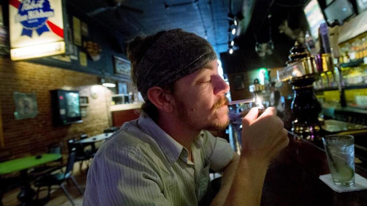 Cody Jones of Macon lights a cigarette at The Hummingbird Stage & Taproom last year. Jones, who has been smoking since he was 14, was not surprised that Macon-Bibb's smoking rate is higher than the national and state average.