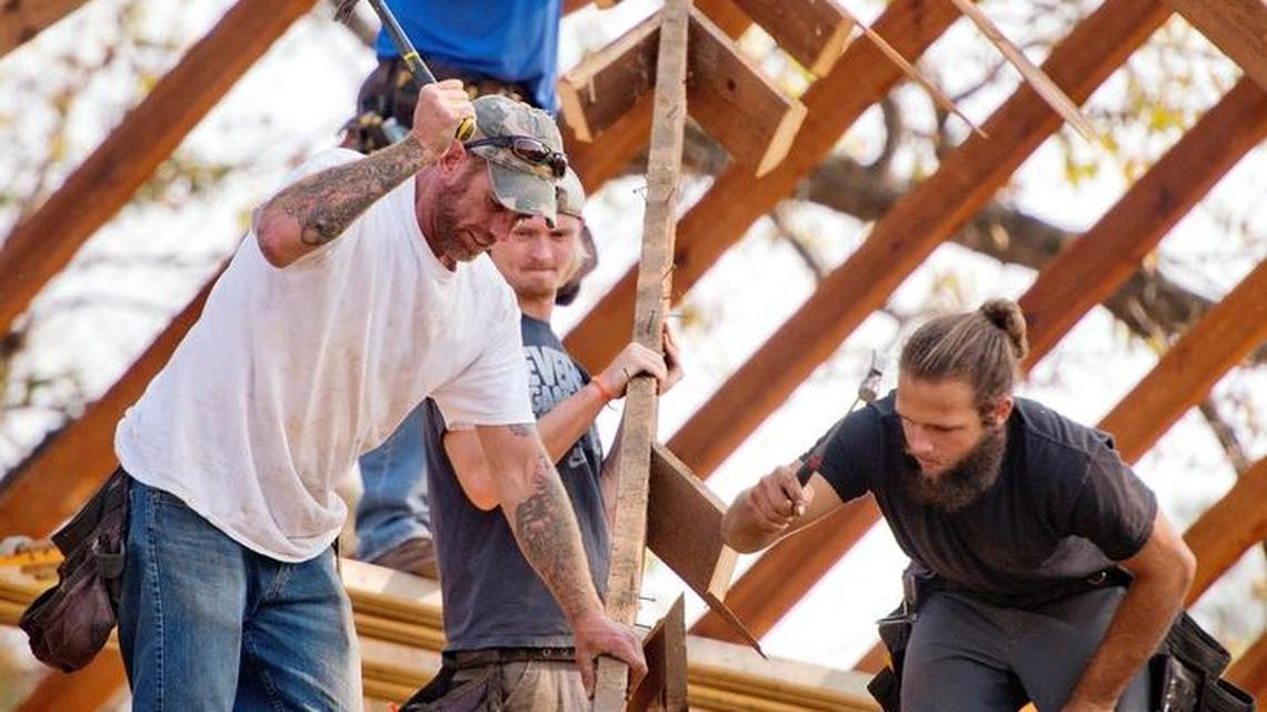Jesse Baker, left and Brandon Whited, right, hammer on a ceiling rafter while helping break down the roof of a house on Elberta Road Monday afternoon. The house, which is one of the oldest in Warner Robins, will be moved Sunday to the new Wellston Park and converted into an office and public meeting space.