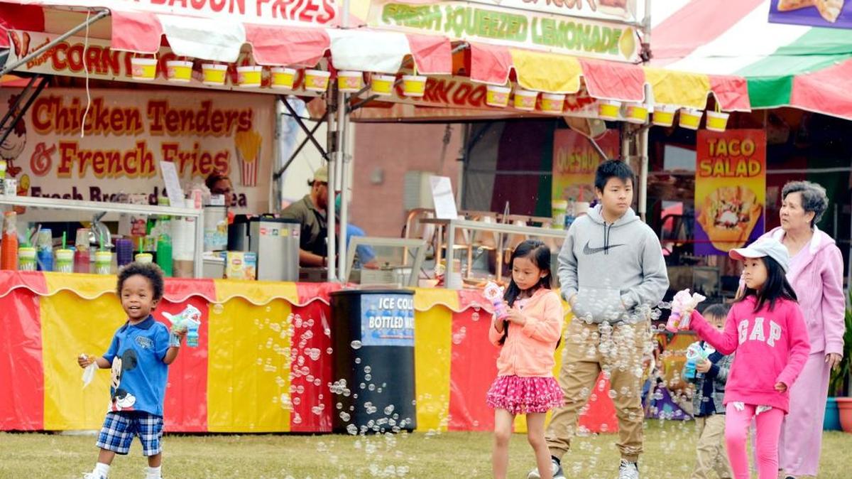 Children enjoy their new bubble guns while entering Central City Park during the Cherry Blossom Festival last year in this Telegraph file photo.