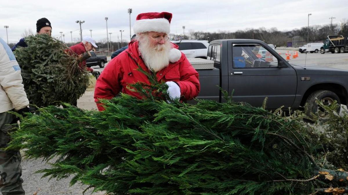 Volunteer Glenn Heald unloads a Christmas tree at the Bring One to the Chipper event behind Luther Williams Field at Central City Park in 2014 in Macon.