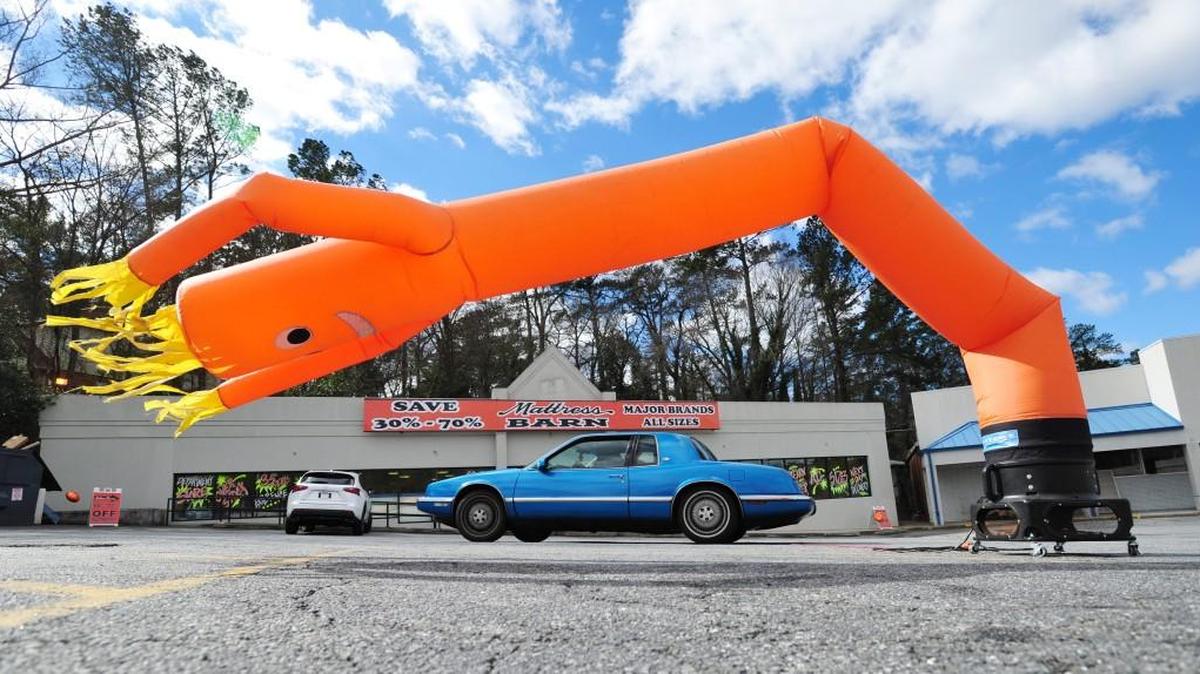 A 1992 Buick Riviera that it's driver, "Bigeem", has named "Blueberry" drives by a inflatable dancing man in the Mattress Barn parking lot at the corner of Riverside Drive and Pierce Avenue during a wind advisory in 2015. A wind advisory for Thursday is posted for much of Georgia.