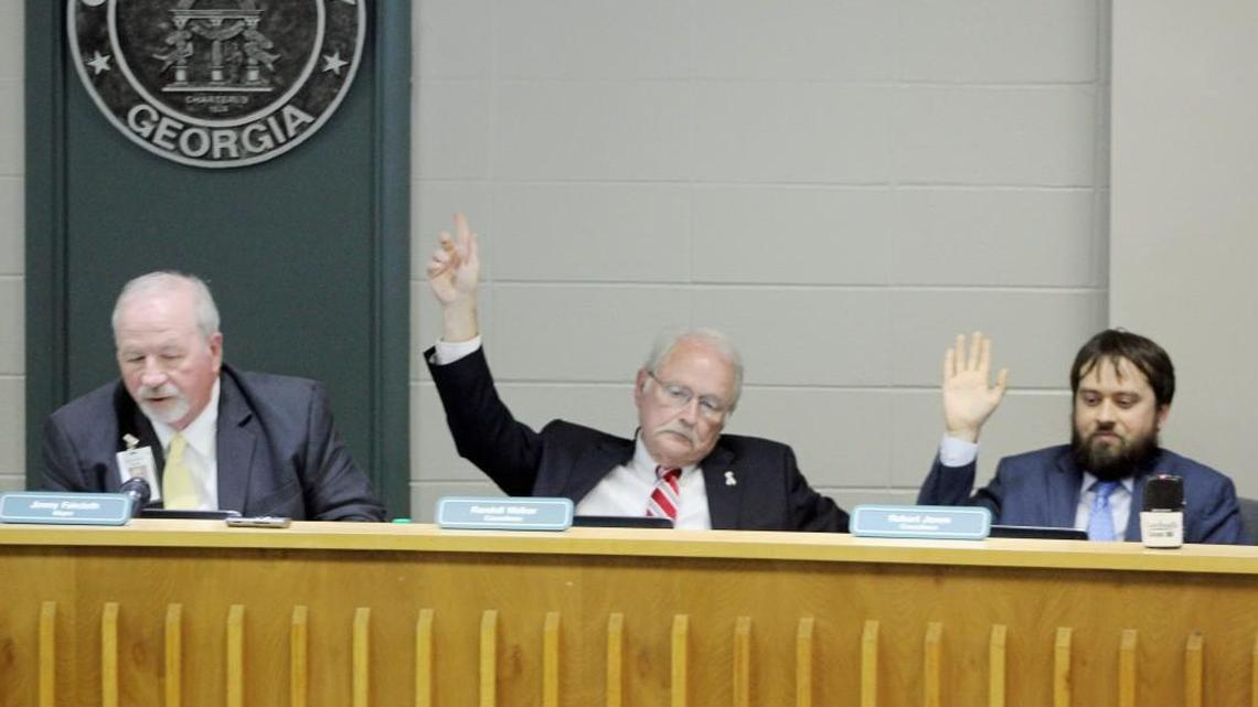 Perry city council members Randall Walker, center, and Robert Jones cast a vote in favor of remanding an annexation and rezoning request back to the Planning Commission as Mayor Jimmy Faircloth checks the vote.