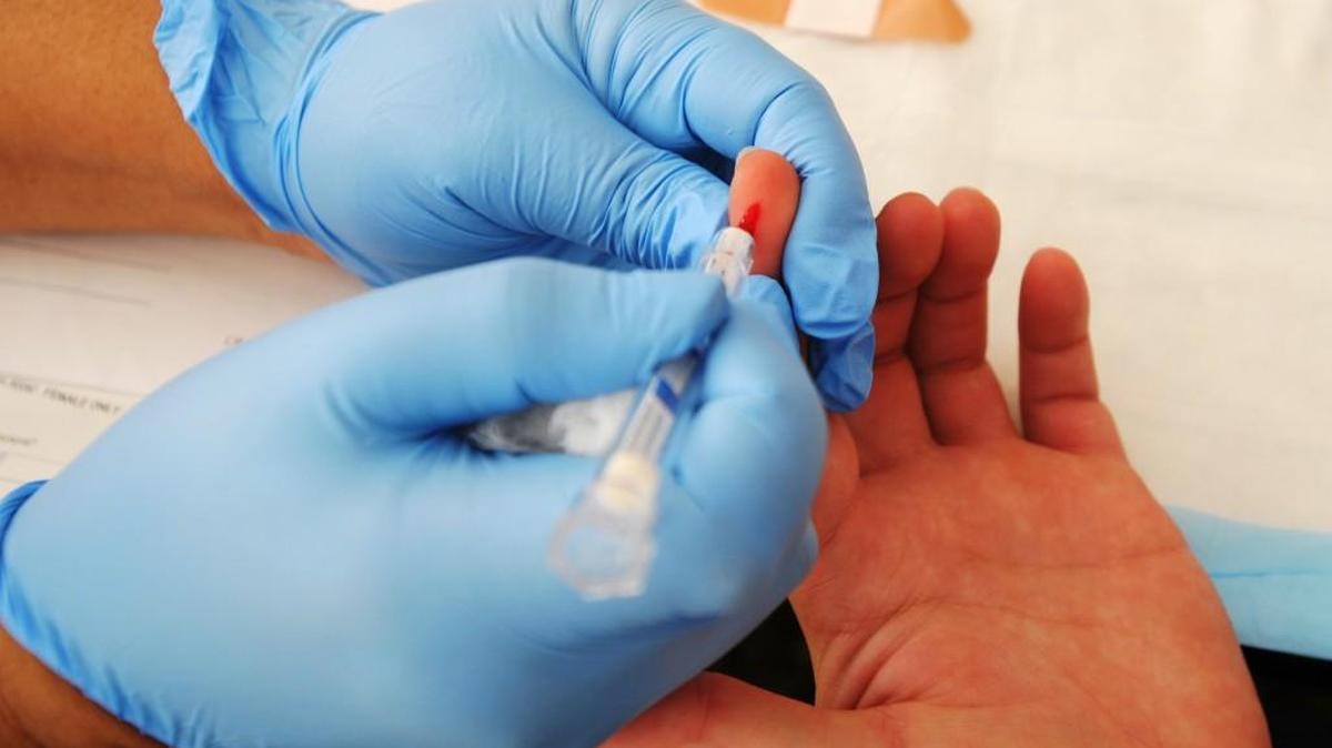 Brittney Sumlin of Macon has a small amount of blood drawn from her finger by Sharon Jacobs with Ogeechee Behavioral Services at the Healing Stigma National HIV Testing Day event at River Edge Behavioral Health in June 2013.