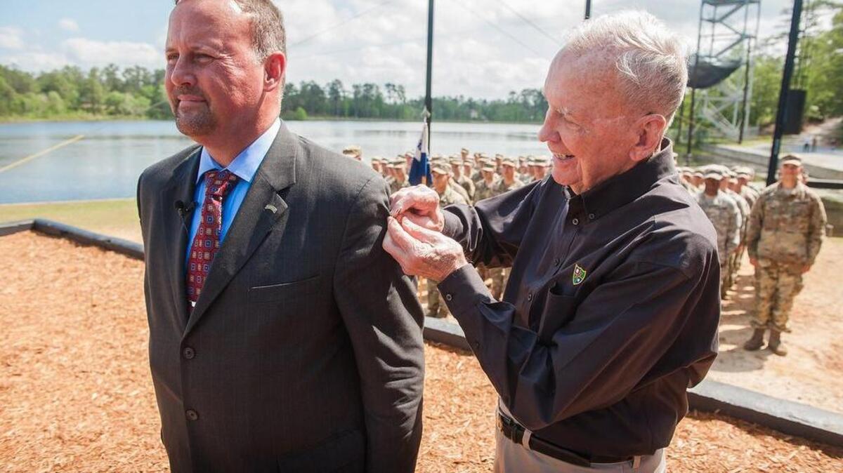 Retired U.S. Army Col. Keith A. Landry, left, receives his Ranger tab on Friday from retired Col. Ralph Puckett on Friday during Ranger School graduation at Victory Pond on Fort Benning.