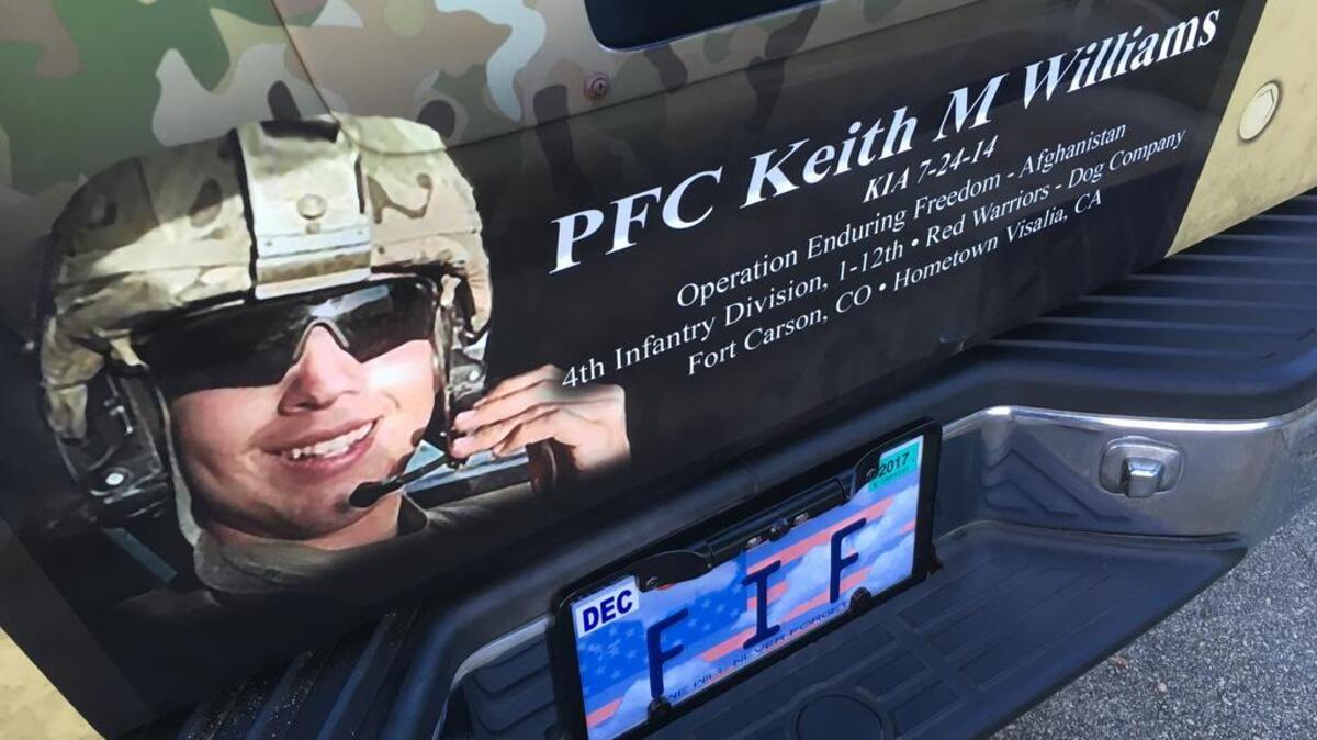 The tailgate of the 2004 Nissan Titan pickup truck is a memorial to its owner, Keith Williams.