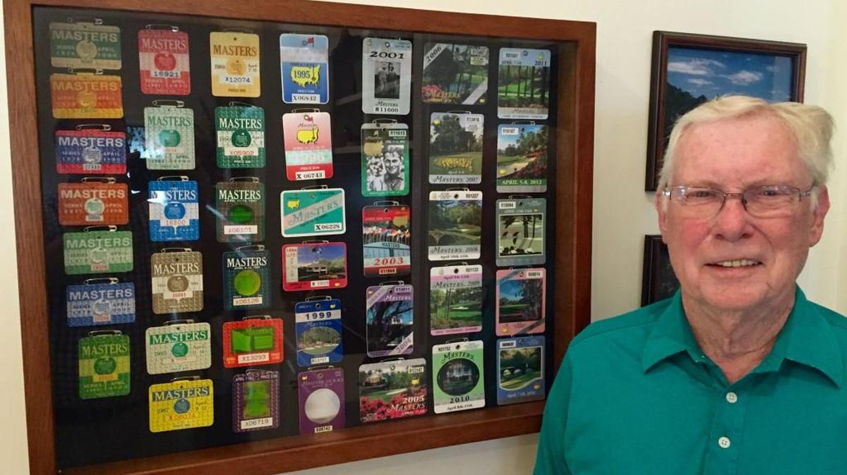 Charles Gibbs poses for a photo with his collection of Masters badges.
