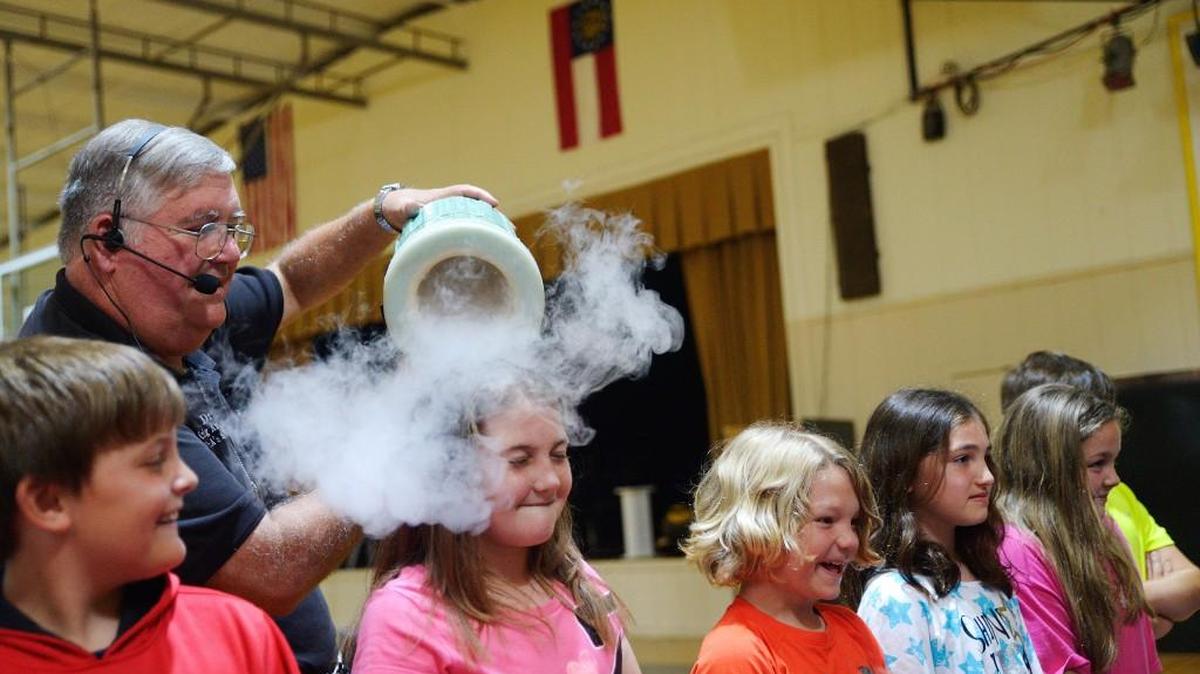 Craig Anderson pours a cloud, water vapor cooled by a vessel that had held liquid nitrogen, over the head of a Flint River Academy student during one of his science presentations in this 2014 file photo.