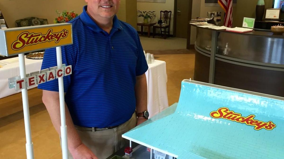Brad Moore stands beside a model he made of a Stuckey’s store.