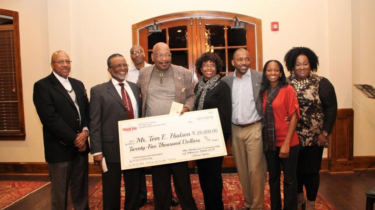 Outgoing Bibb County school board member Tom Hudson accepts a check for $25,000 from community members at a sendoff reception Dec. 11, 2016.