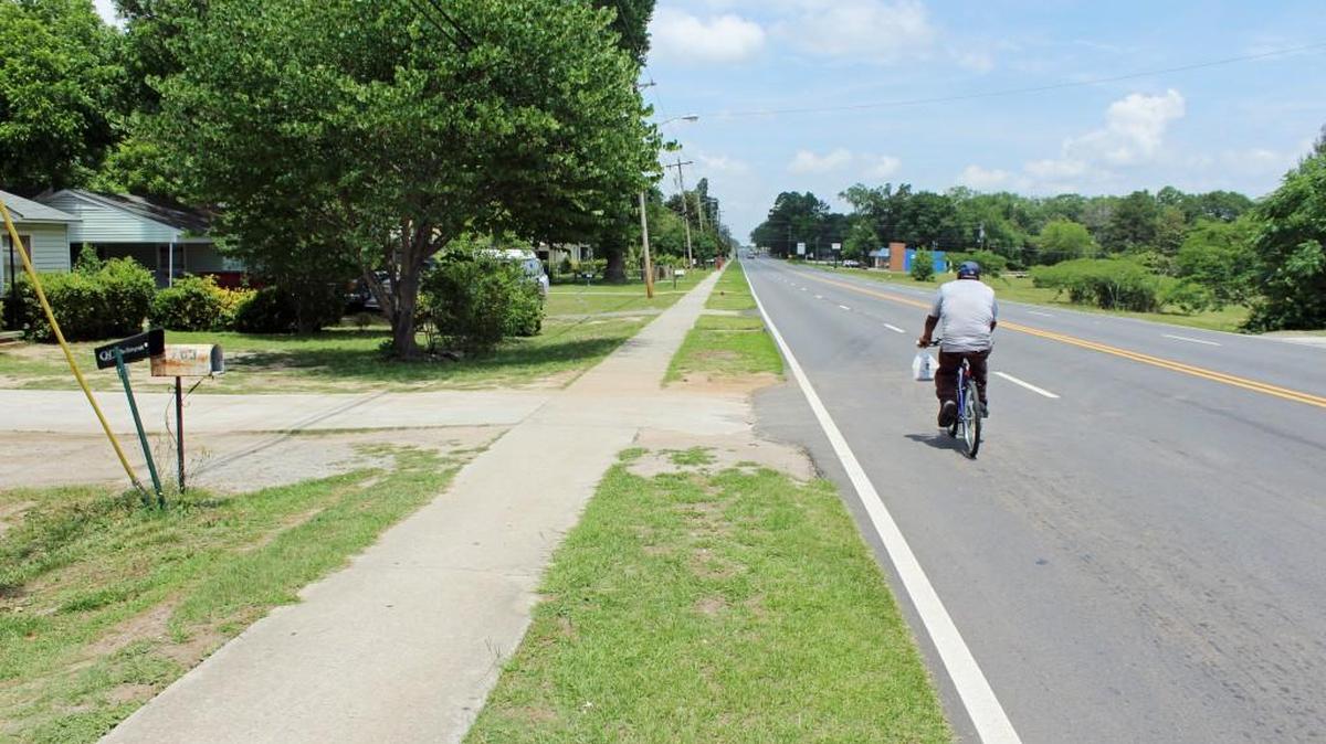 A man pedals along North Davis Drive in Warner Robins on Thursday. Low-income homeowners who live in an area centered by Davis Drive may be eligible for a grant of up to $5,000 to repair their homes.