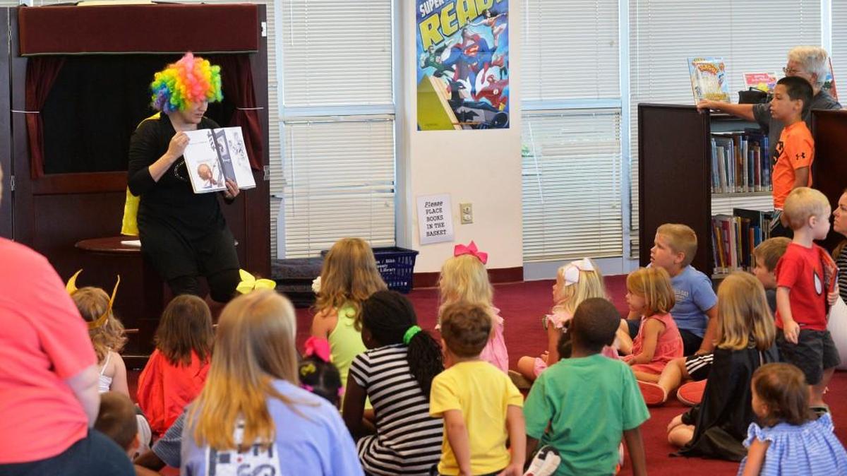 Virginia Elliott, left, reads to children at the Riverside branch of the Middle Georgia Regional Library on July 10, 2015 during the last program of the summer —``Superheroes.''