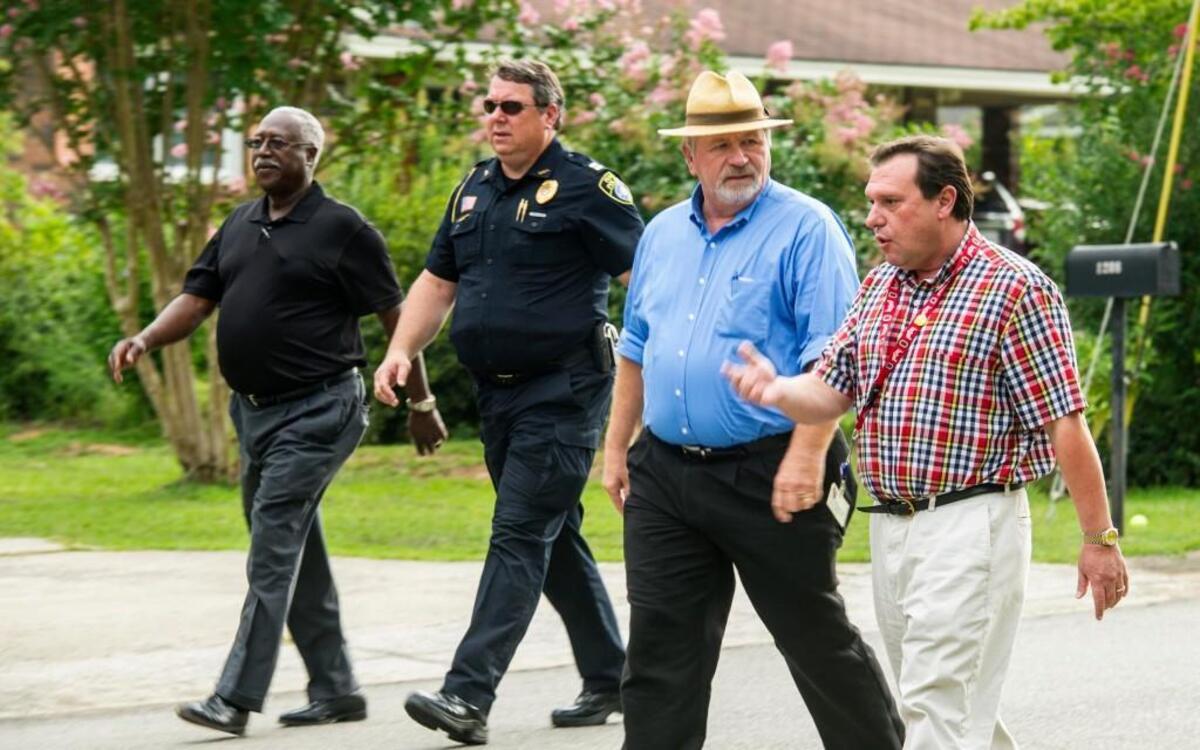 Perry Mayor Jimmy Faircolth, second from right, listens to Morrison Guidry, right, as they walk through a Perry neighborhood July 28, 2015. The mayor and City Council members walk through a different neighborhood every fourth Tuesday.