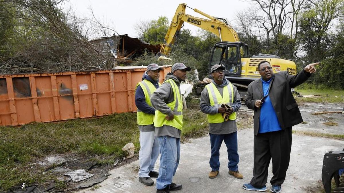 Macon-Bibb County Commissioner Al Tillman points out where another blighted house is scheduled to be demolished to contractions tearing down a house at 3936 Mercer Street in this March 3, 2017, file photo. Two Mercer Street homes were torn down Monday as part of a new Bibb County sheriff’s precinct and fire station.