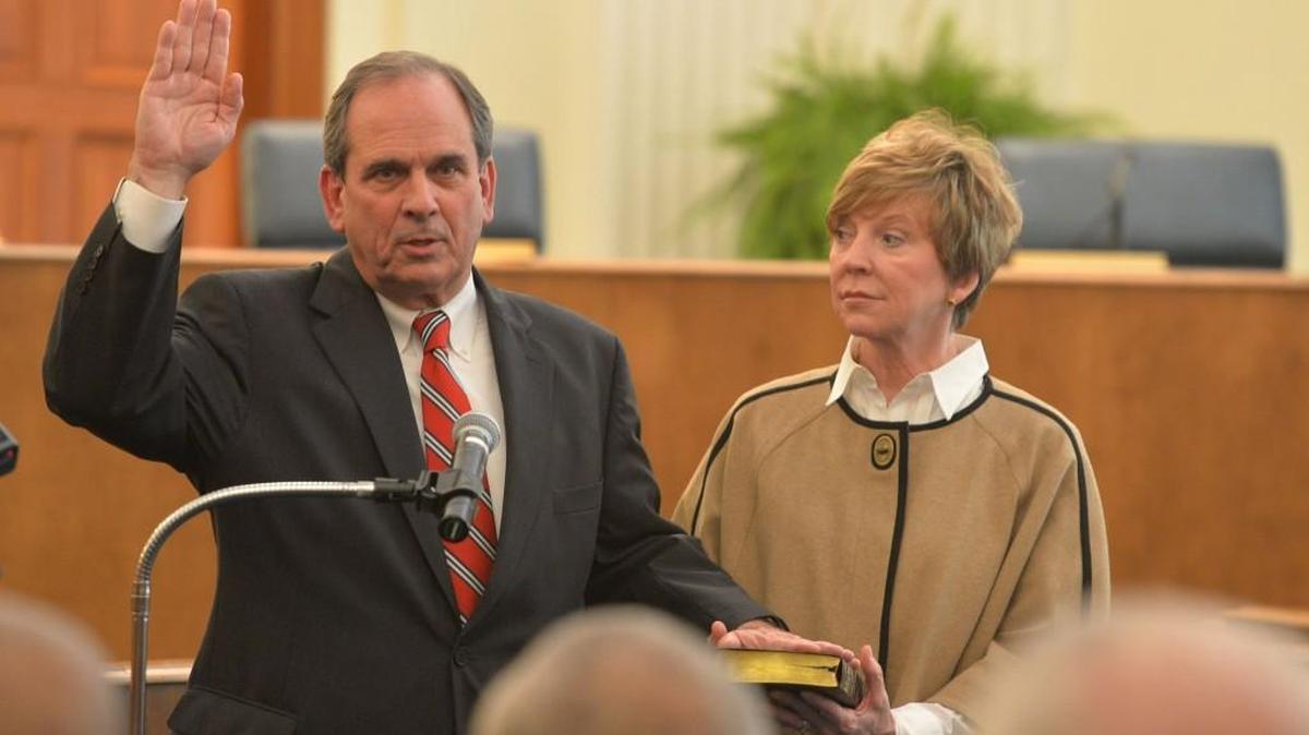 Mayor Robert Reichert takes his oath of office on Dec. 31, 2013, with wife Dele holding the family Bible.