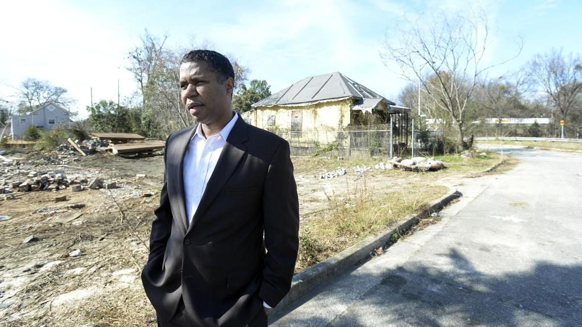 State Rep. James Beverly stands in front of the house Little Richard Penniman grew up in on Fifth Ave. in Pleasant Hill where work is well underway demolishing and moving houses, part of the process of widening Interstate 75.
