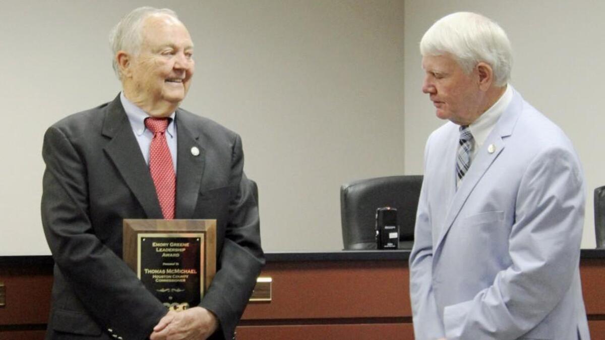 Houston County Commissioner Jay Walker, right, congratulates Commissioner Tom McMichael on winning the Emory Greene Leadership Award at the annual Association County Commissioners of Georgia convention held Sunday.