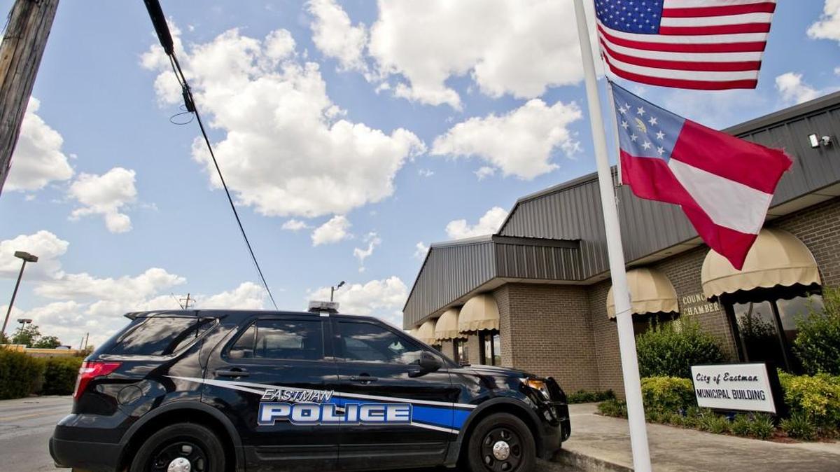 Flags fly at half-staff in front of the City of Eastman Municipal Building on Sunday afternoon. Eastman police Officer Tim Smith was shot and killed in the line of duty Saturday night.