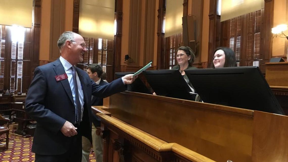 Macon Republican state Rep. Allen Peake gives two medical cannabis bills to staff on the Georgia state House floor on Thursday. The lawmaker wants to set up a public referendum on medical cannabis cultivation in Georgia and to open the state’s medical cannabis registry to more people.
