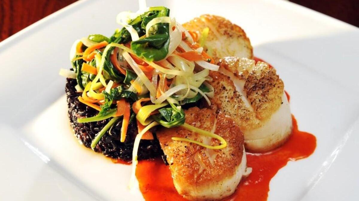 Aubri Lane’s pan seared diver scallops on a sweet pepper coulis with forbidden rice, braised leaks and carrots.