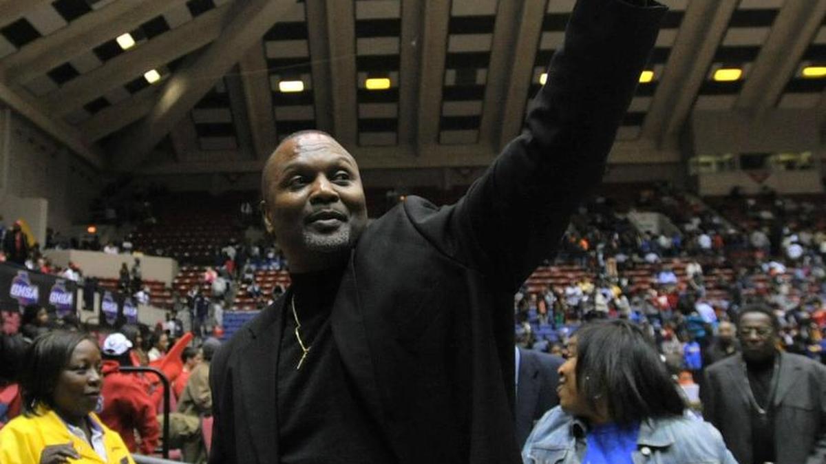 Wilkinson County coach Aaron Geter, Jr. shows fans the trophy as he walks off the court with his team. Wilkinson beat Wilcox, 53-49 to win the GHSA A-public boys state championship in 2013.