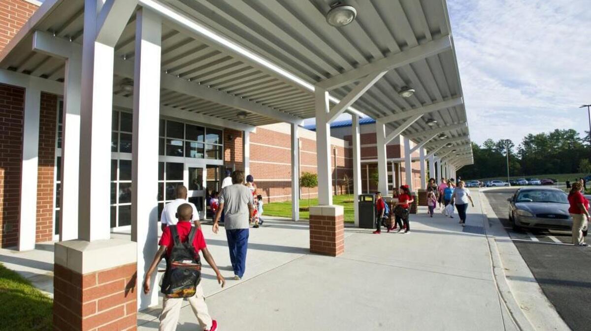 Parents and students stream into Veterans Elementary on the first day of school in Bibb County in August. Veterans Elementary is one of three Bibb schools being considered for state intervention.