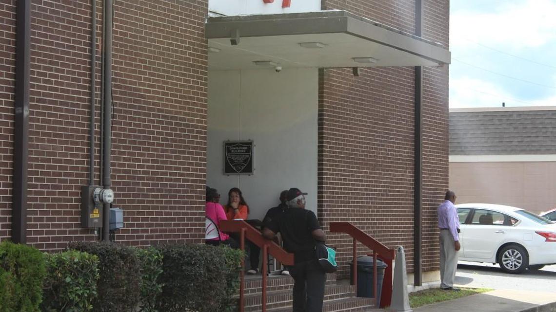 People stand outside the headquarters of American Federation of Government Employees Local 987 in Warner Robins on Thursday as a hearing is held on allegations against the former union leadership.