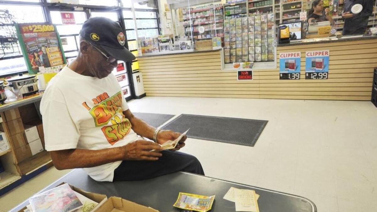 Ben Evans puts his lottery tickets in a special wallet in a convenience store on Pio Nono Avenue in Macon in this Telegraph file photo.