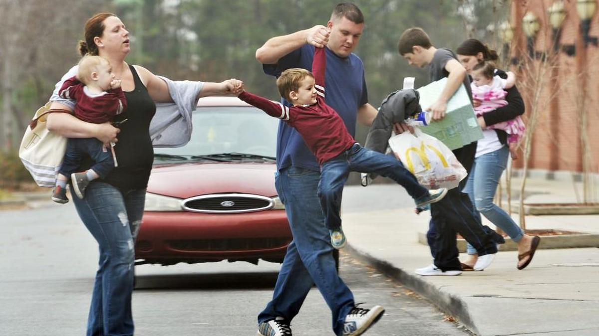 Tammy and Steven Hill swing son Brock, 4, into Target, where he was more than willing to continue the hunt for more and better toys Dec. 26, 2016. The Perry couple -- along with younger son, Robert, 9 months old -- agreed that their family time was precious, especially since Steven was working six days a week and long hours just before the holiday.