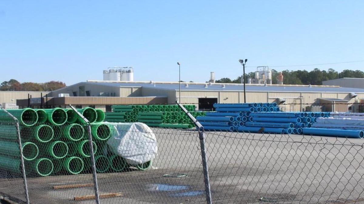 Plastic pipes made by Diamond Plastics in Macon sit outside the plant Wednesday morning after a man was crushed by pipes inside the plant.