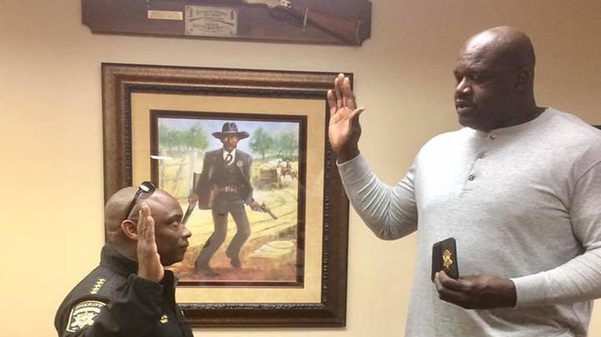 Shaquille O’Neal is sworn in by Clayton County Sheriff Victor Hill as a sheriff’s deputy on Dec. 3, 2016.