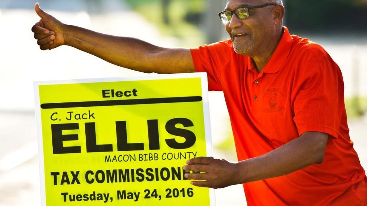 Macon-Bibb County tax commissioner candidate C. Jack Ellis waves at passing cars as he campaigns at the corner of Pio Nono Avenue and Rocky Creek Road on Tuesday morning.