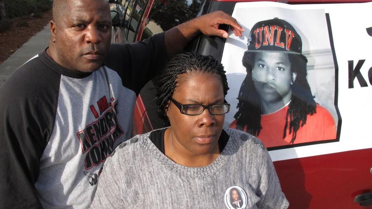In this Dec. 13, 2013 file photo, Kenneth and Jacquelyn Johnson stand next to a banner on their SUV showing their late son, Kendrick Johnson in Valdosta.