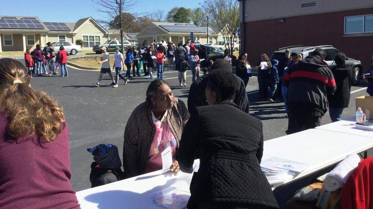 Carla Flag, 58, of Macon, center, was among about 700 people helped by a massive food distribution by five major community agencies Saturday at the Buck Melton Community Center. “It’s good to give back to the community,” Flag said of the effort. “It’s good to help people in daily life because people need food.”